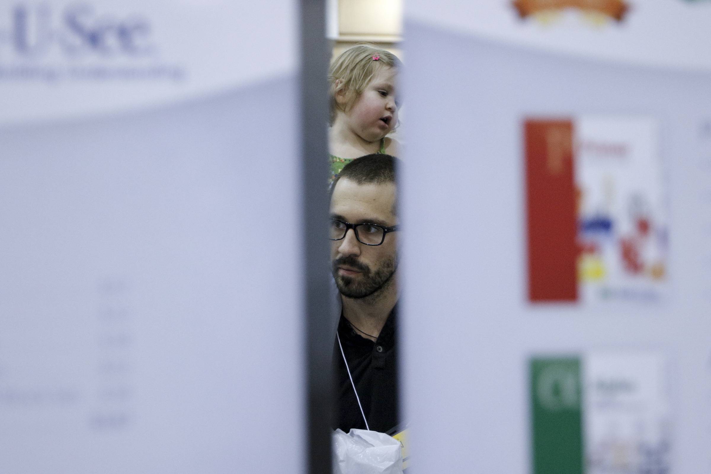 Ian Myers carries his daughter Zoey on his shoulders as they listen to a presentation about a math curriculum at the 32nd Annual Education Expo & Homeschool Curriculum Fair on Saturday, July 18, 2015, at Camp Jordan Arena in Chattanooga, Tenn.