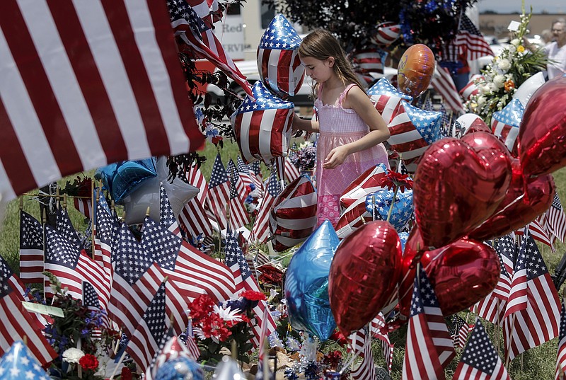 Colette Smith places balloons on a Lee Highway memorial for victims of the July, 16 shootings on Saturday, July 18, 2015, in Chattanooga, Tenn. U.S. Navy Petty Officer Randall Smith died Saturday from wounds sustained when gunman Mohammad Youssef Abdulazeez shot and killed four U.S. Marines and wounded two others and a Chattanooga police officer at the Naval Operational Support Center on Amnicola Highway shortly after firing into the Armed Forces Career Center on Lee Highway.