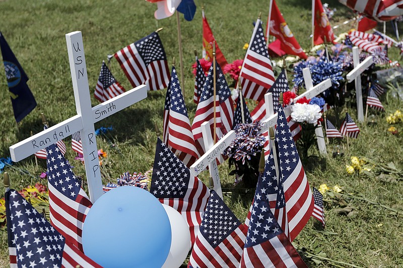 A cross placed for U.S. Navy Petty Officer Randall Smith, who was injured July, 16 shootings and died Saturday morning, is seen at a Lee Highway memorial on Saturday, July 18, 2015, in Chattanooga, Tenn. Petty Officer Smith died Saturday from wounds sustained when gunman Mohammad Youssef Abdulazeez shot and killed four U.S. Marines and wounded two others and a Chattanooga police officer at the Naval Operational Support Center on Amnicola Highway shortly after firing into the Armed Forces Career Center on Lee Highway.