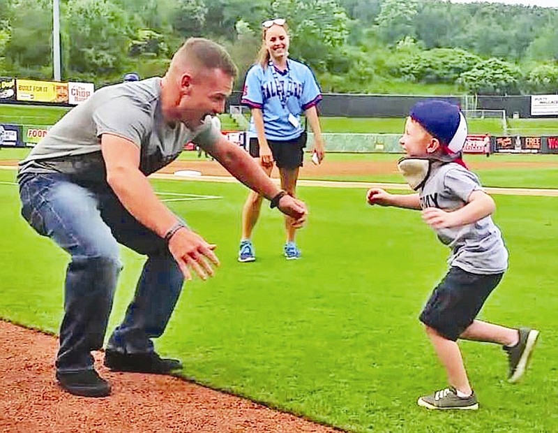 
              In a July 3, 2015 photo provided by the Dowell family, Brayden Dowell, right, runs to his father Sgt. Adam Dowell’s waiting arms during a surprise homecoming at a Tennessee Smokies game in Kodak, Tenn. Dowell had just returned home from a 10-month deployment. (Lisa Dowell via AP)
            