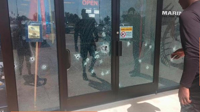 Photo shows front of Lee Highway recruiting office riddled with bullets from a Chattanooga gunman. A sign on the office prohibited firearms inside. 