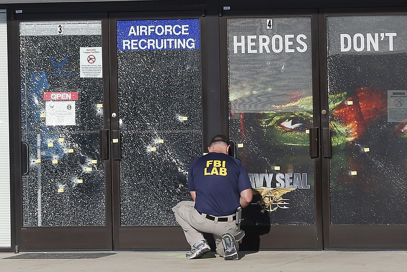 An FBI investigator investigates the scene of a shooting outside a military recruiting center on Friday, July 17, 2015, in Chattanooga