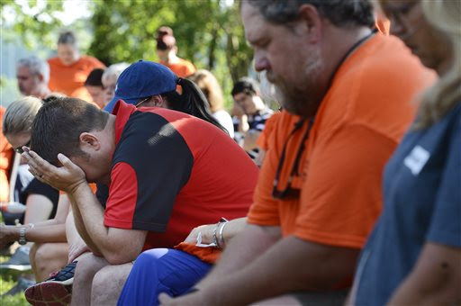 Rodney Gray, left, prays during a memorial service at River Park Saturday, July 18, 2015, in Chattanooga, Tenn., for the victims of the Tennessee shootings. Muhammad Youssef Abdulazeez, of Hixson, Tenn., attacked two military facilities on Thursday, in a shooting rampage that killed four Marines and one U.S. Navy sailor. (AP Photo/Mark Zaleski)