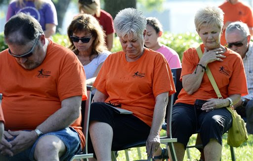 Teen Challenge member, Carol Parker, center, becomes emotional during a memorial service at River Park Saturday, July 18, 2015, in Chattanooga, Tenn., for the victims of the Tennessee shootings. The U.S. Navy says a sailor who was shot in the attack on a military facility in Chattanooga has died, raising the death toll to five people. (AP Photo/Mark Zaleski)