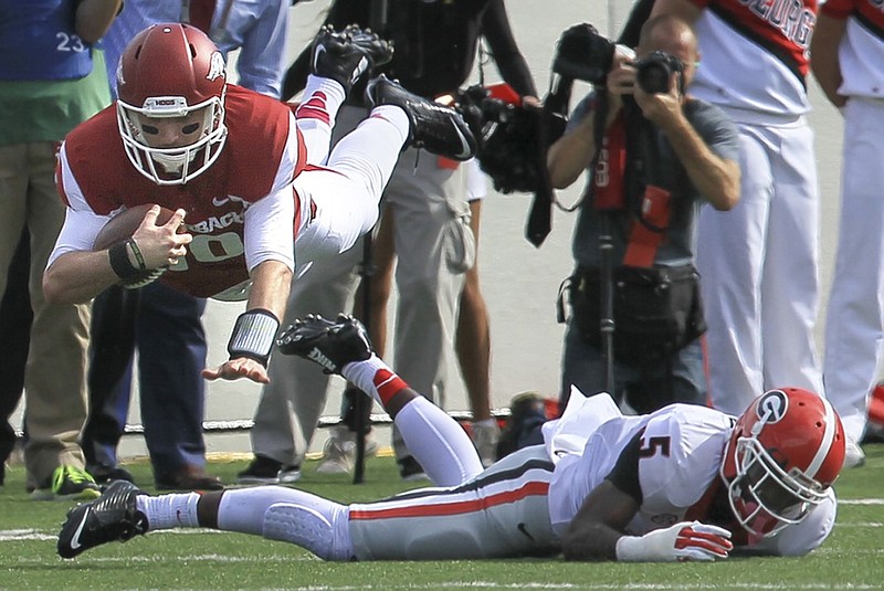 Arkansas quarterback Brandon Allen leaps over Georgia defender Damian Swann during the first quarter of the Razorbacks' 45-32 loss in a Southeastern Conference matchup last season at War Memorial Stadium in Little Rock.