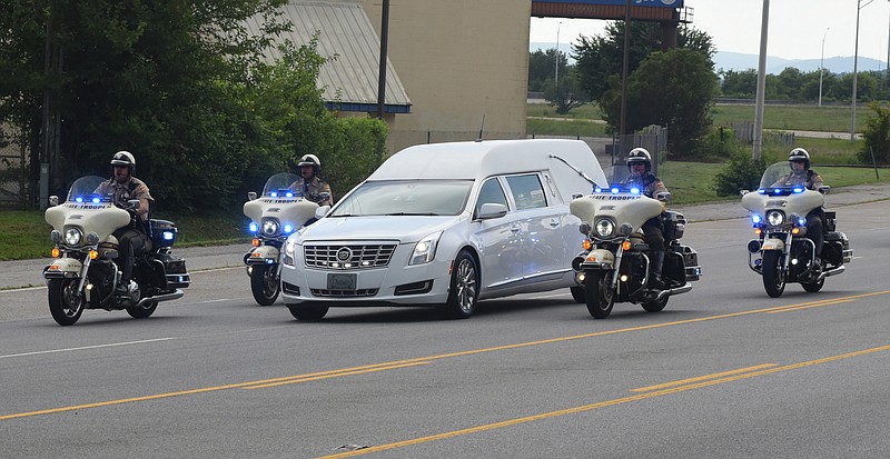 Members of the Tennessee Highway Patrol and the Chattanooga Police Department escort a hearse carrying the body of slain U. S. Navy Petty Officer 2nd Class Randall Smith on Amnicola Highway just past the U. S. Naval and Marine Reserve Center on Sunday, July 19, 2015, in Chattanooga, Tenn. Before the body was taken to the Chattanooga Metropolitan Airport, the motorcade drove past both shooting scenes from last Thursday's terrorist attack that killed Smith and four Marines. 