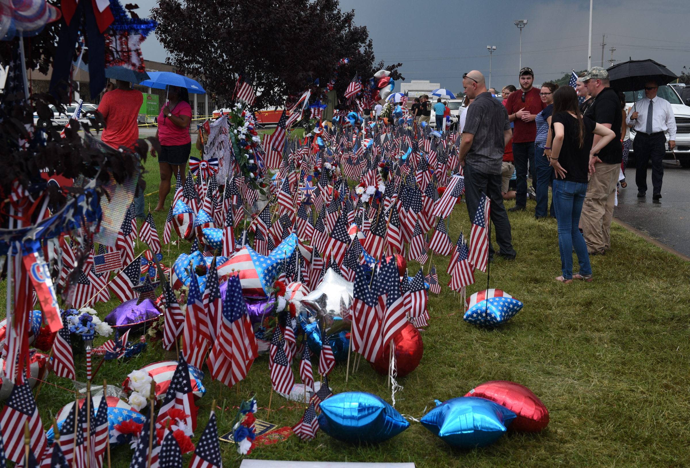 Seen on Sunday, July 19, 2015, in Chattanooga, Tenn., balloons, flags, signs and other mementos make up a memorial in front of the Armed Forces Career Center on Lee Highway in the aftermath of a Thursday terrorist attack that killed four Marines and one member of the U.S. Navy.