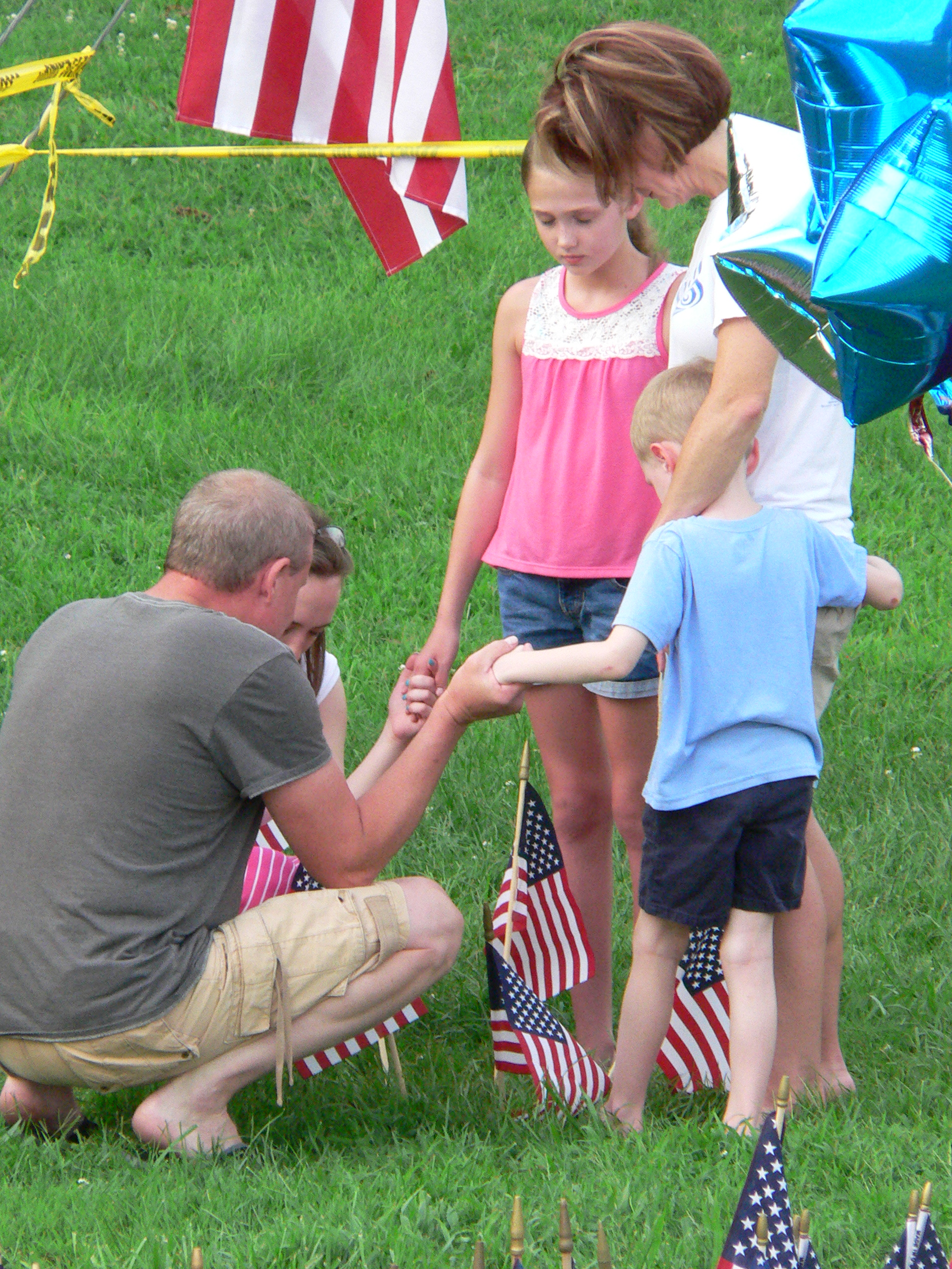 A family prays for the fallen at the memorial on Amnicola Highway.
