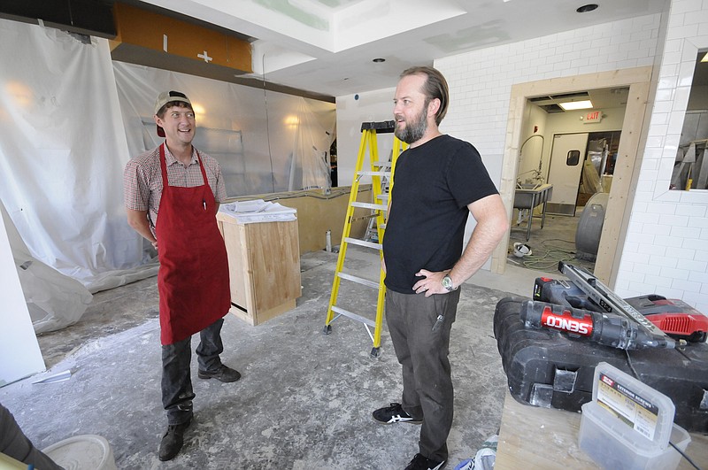 Main Street Meats front house manager Brent Harding, left, listens as Executive Chef and Owner Erik Niel talks about the new expansion of the business into a 40-seat restaurant on the existing East Main Street site in this June 19, 2015 photo.