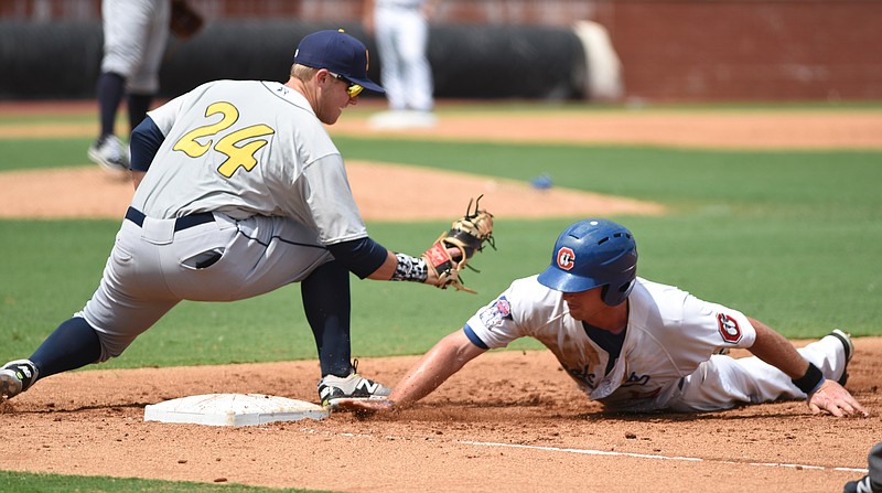 Chattanooga's Travis Harrison slides safely back to first base just ahead of the tag of Montgomery's Jake Bauers as the Lookouts host the Montgomery Biscuits on Tuesday, July 21, 2015, in Chattanooga, Tenn. The Lookouts lost 8-4 in 10 innings. 