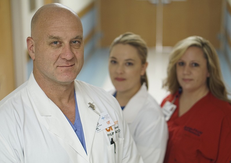 Erlanger ICU surgeon Dr. Philip Smith, Trauma Program Manager Angela Basham-Saif and Critical Care Nurse Clinician Jana Jackson, from left, stand in front of the trauma ward at Erlanger on Tuesday, July 21, 2015, where they attempted to save U. S. Navy Petty Officer 2nd Class Randall Smith after he was shot by Mohammad Youssuf Abdulazeez last Thursday. 