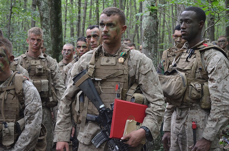 During a field exercise on July 15, 2nd Lt. Matthew George, a student at The Basic School, listens to comments from his commanding officer after receiving a Navy and Marine Corps Achievement Medal for his lifesaving actions taken on June 21.