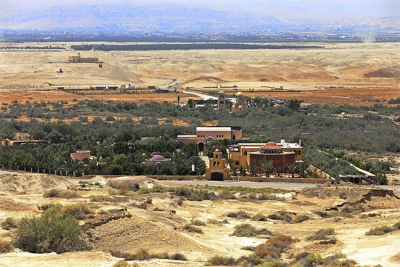 This July 6, 2015 photo shows the baptismal area on the eastern bank of the Jordan River in South Shuna, Jordan, foreground, and the baptismal area of the Israeli-run site known as Qasr al-Yahud, with the golden dome church, background, located in a part of the West Bank. UNESCO recently designated Jordan's baptismal area a World Heritage site, over the Israeli-run site of Qasr al-Yahud in the West Bank, which is one of three territories captured by Israel in the 1967 Mideast war. (AP Photo/Raad Adayleh)
