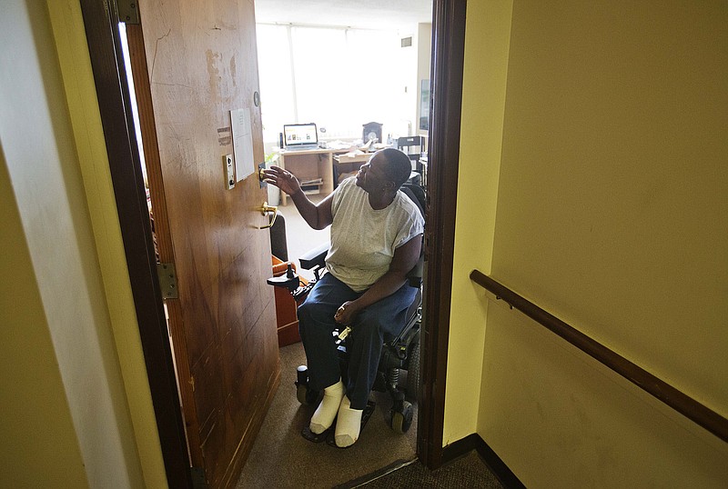 Sharon Bridges checks a flier posted to her apartment door at the Friendship Tower apartments Monday, July 20, 2015, in Atlanta. 