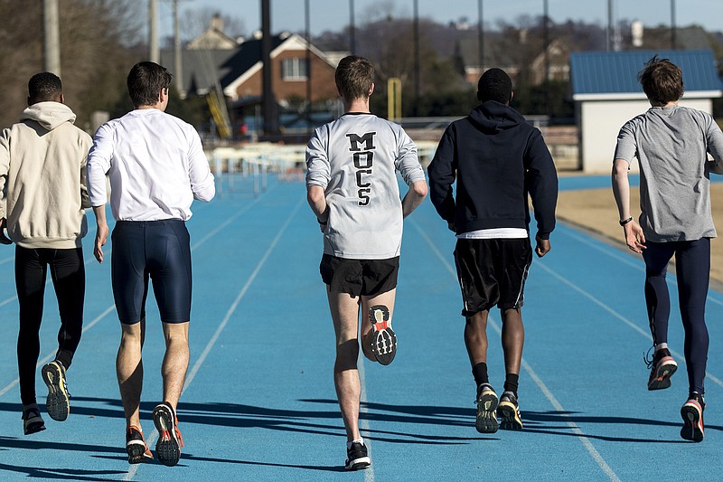 UTC track and field athletes warm up Wednesday, Jan. 28, 2015, at the GPS athletic fields, where the team practices, in Chattanooga. UTC announced Tuesday that they are ending the men's track program.