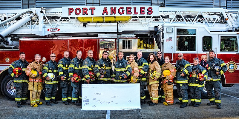 Firefighters and EMTs from the Port Angeles Fire Department and Clallam County No. 2 Fire-Rescue signed the 6-foot sympathy banner for Chattanooga..
