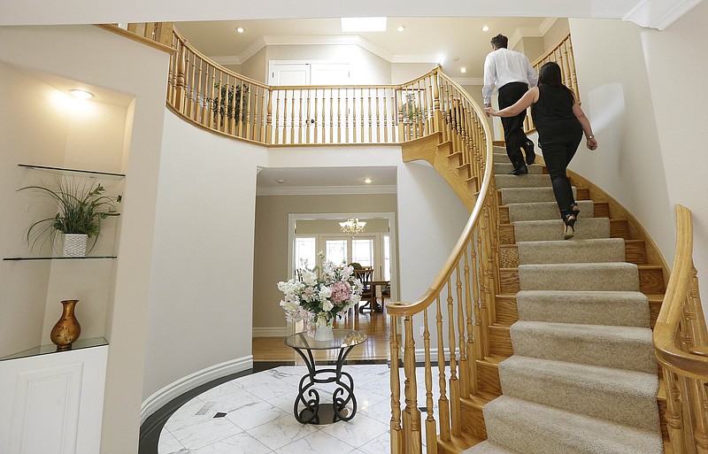 
              In this photo taken, May 6, 2015, realtor Stephan Marshall, top, walks with potential buyer Sasha Martinez at a home for sale in Pacifica, Calif. The National Association of Realtors releases existing home sales for June on Wednesday, July 22, 2015. (AP Photo/Jeff Chiu)
            