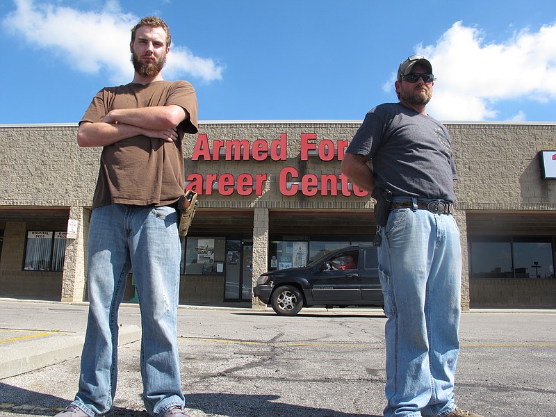 In this photo taken Tuesday, July 21, 2015, Allen Bowles, left, and Clint Janney stand guard outside a military recruiting center in Columbus, Ohio.
