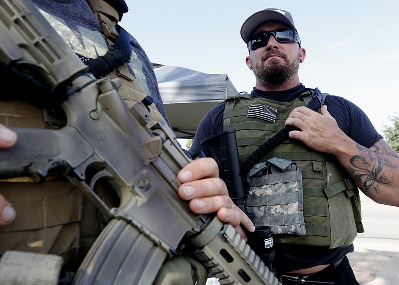 Jerry Blakeney stands guard with other members of Operation Hero Guard outside a U.S. military recruiting station in Cleburne, Texas, Tuesday, July 21, 2015. Gun-toting citizens are showing up at military recruiting centers around the country, saying they plan to protect recruiters following last week's killing of four Marines and a sailor in Chattanooga, Tenn. (Rose Baca/The Dallas Morning News via AP) 