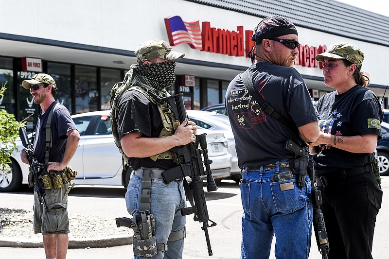 A small group of armed citizens stand guard outside a Colorado Springs, Colo., Armed Forces Career Center Wednesday, July 22, 2015. Gun-toting citizens are showing up at military recruiting centers around the country, saying they plan to protect recruiters following last week's killing of four Marines and a sailor in Chattanooga, Tenn. (Michael Ciaglo/The Gazette via AP) 