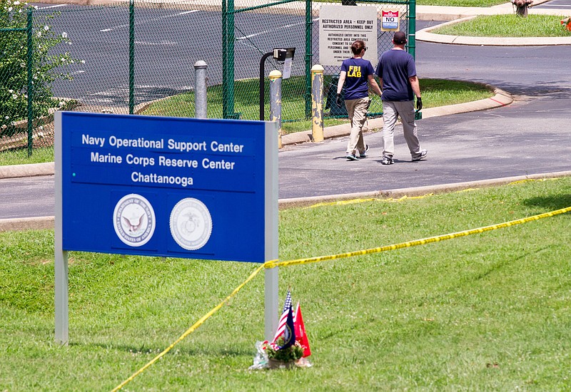Investigators walk by the entrance of a Navy and Marine center in Chattanooga, Tenn., on Wednesday, July 22, 2015. Law enforcement officials for the first time provided details about how Muhammad Youssef Abdulazeez crashed the gates with his car and opened fire on the service members inspecting equipment there, killing four Marines and one sailor. (AP Photo/Erik Schelzig)
