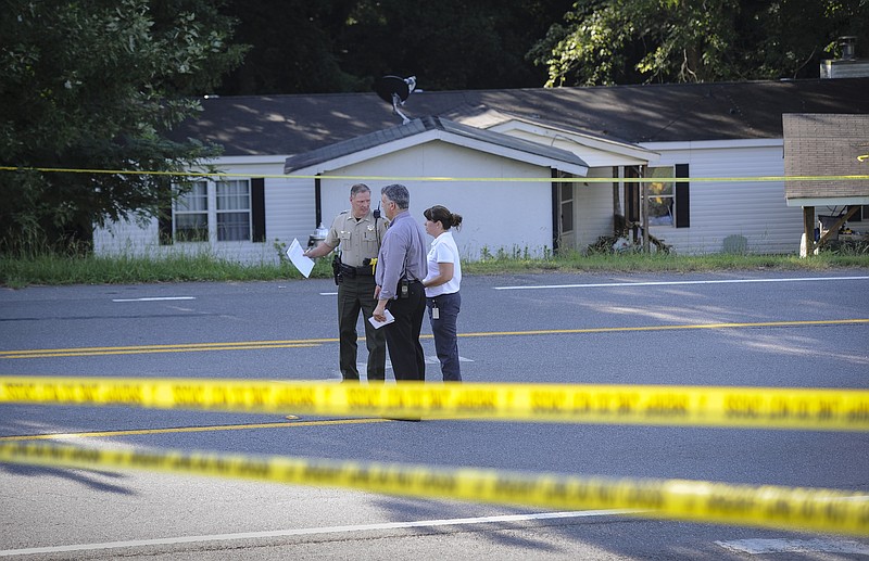 Law enforcement investigate the scene of a shooting at a home in Suwanee, Ga., Wednesday, July 22, 2015. Officers initially found three people dead and two wounded, including the suspect, Forsyth County sheriff's officials said. The wounded were taken to hospitals, where one died, Deputy Robin Regan said. But it wasn't clear whether that was the suspect or the other person.