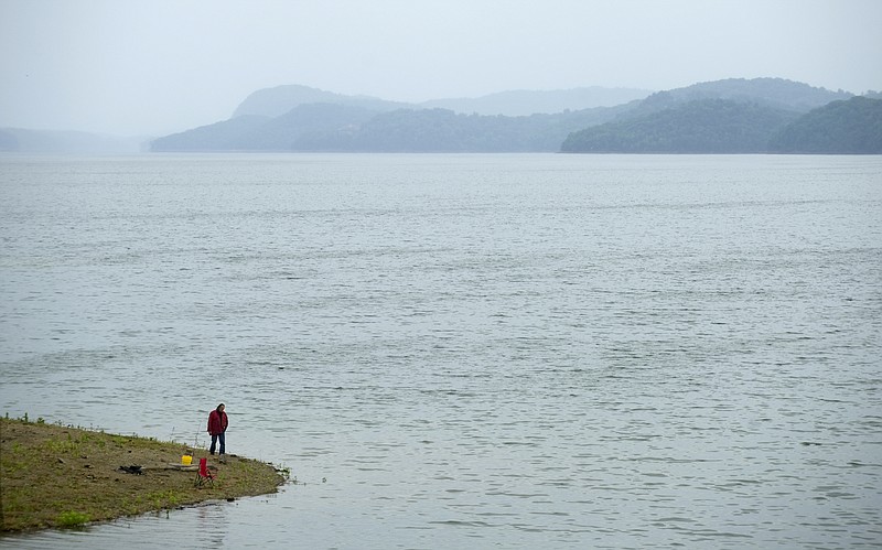 A fisherman walks along the bank of Tennessee Valley Authority's Cherokee Reservoir near Jefferson City, Tenn., in this 2012 file photograph.