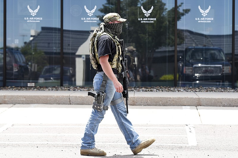 Scott, a civilian who wished not to provide his last name, walks in front of the Air Force recruiting office as he stands guard outside a Colorado Springs Armed Forces Career Center on Wednesday. Gun-toting citizens are showing up at military recruiting centers around the country, saying they plan to protect recruiters following last week's killing of four Marines and a sailor here in Chattanooga. (Michael Ciaglo/The Gazette via AP) MAGS OUT; MANDATORY CREDIT