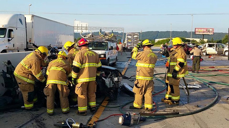 Emergency personnel work at the scene of a nmultiple fatality wreck at Exit 11 in Ooltewah.