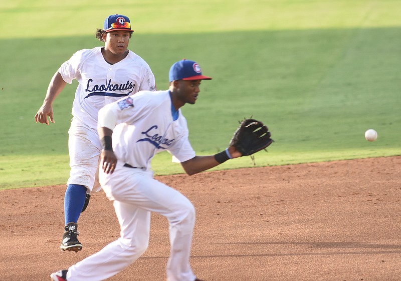 Lookouts' third baseman Niko Goodrum makes a defensive play as Heiker Meneses, left, moves in to back him up early in the game Thursday against the Tennessee Smokies.