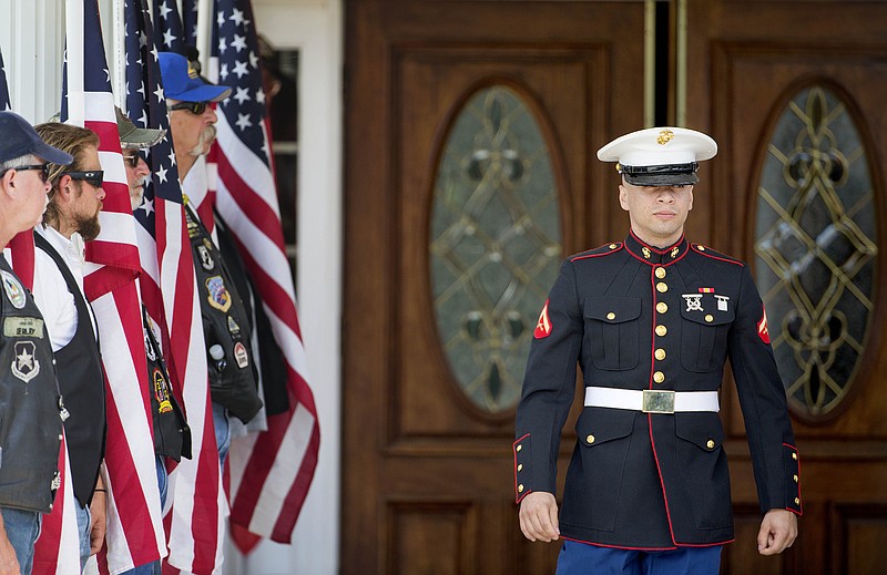 A U.S. Marine walks out of the visitation of Lance Cpl. Skip Wells on Friday, July 24, 2015, in Kennesaw, Ga.