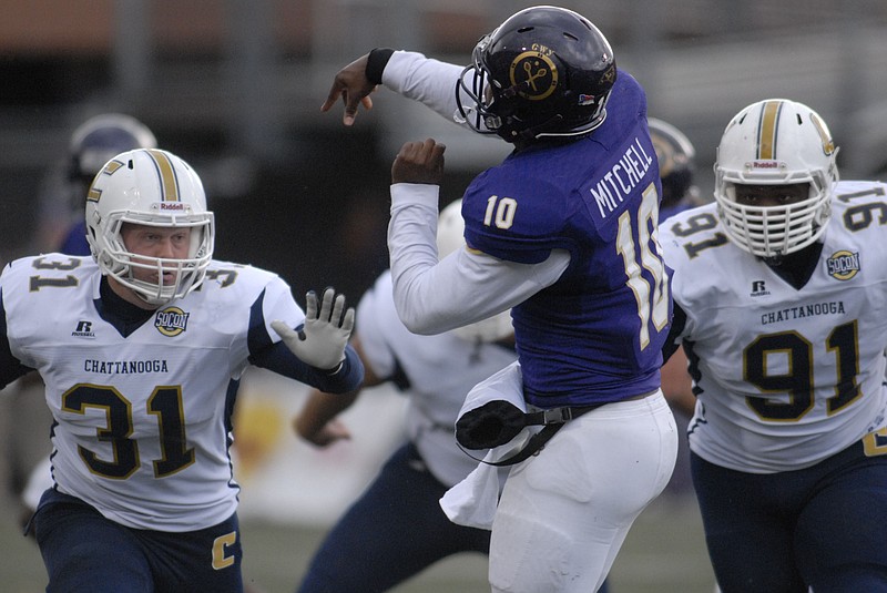UTC defenders pressure Western quarterback Troy Mitchell (10) in this 2014 file photo.