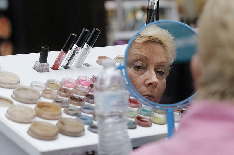Shirley McMasters looks at sample makeup in a mirror at the Chattanooga Convention Center during the She Expo on Saturday, July 25, 2015, in Chattanooga, Tenn. Celebrity Leigh Anne Tuohy was the expo's guest star on Saturday.
