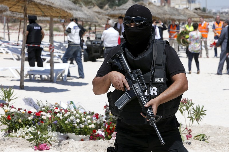 
              FILE - In this Monday, June 29, 2015 file photo, a hooded Tunisian police officer stands guard ahead of the visit of top security officials of Britain, France, Germany and Belgium at the scene of Friday's shooting attack in front of the Imperial Marhaba hotel in the Mediterranean resort of Sousse, Tunisa. Tunisia's parliament on Friday, July 24 voted overwhelmingly to pass the country’s new anti-terror law after a pair of devastating attacks against tourists, but critics fear the new legislation may endanger this North African nation’s hard won freedoms.  (AP Photo/Abdeljalil Bounhar, file)
            