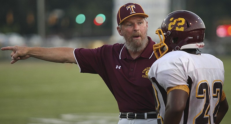 Tyner Academy football coach Wayne Turner shouts instructions to Jaylen Grimes during a game in 2013. Turner is among the area coaches who will not be putting their teams through two practice sessions a day during preseason camp.