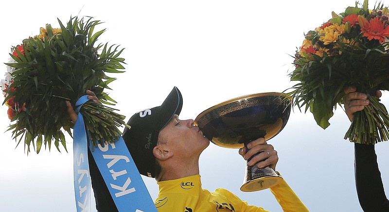 2015 Tour de France cycling race winner Chris Froome of Britain celebrates on the podium after the twenty-first and last stage of the Tour de France cycling race over 109.5 kilometers (68 miles) with start in Sevres and finish in Paris, France, Sunday, July 26, 2015. 