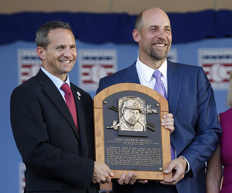 National Baseball Hall of Fame inductee John Smoltz, right, holds his plaque with hall president Jeff Idelson during an induction ceremony at the Clark Sports Center on Sunday, July 26, 2015, in Cooperstown, N.Y.