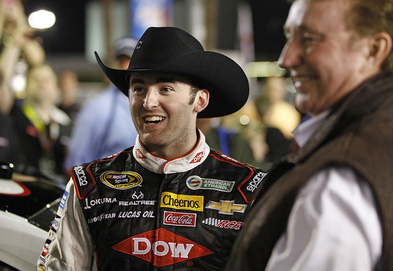 Austin Dillon, left, smiles with team owner Richard Childress, right, before the first of two NASCAR Sprint Cup series qualifying auto races in Daytona Beach, Fla., Thursday, Feb. 20, 2014. (AP Photo/Terry Renna)