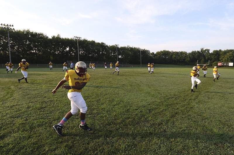 Howard School players warm up during the first day of practice in full pads for the 2015 football season. 