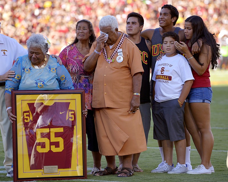 
              FILE- In this Sept. 1, 2012, file photo, family members of Junior Seau including his mother Luisa Seau, far left, and his father Tiaina Seau, third from left, stand during a ceremony to honor the former Southern California player during the first half of an NCAA college football game between Hawaii and Southern California in Los Angeles. The family of the late Junior Seau will not disrupt the Hall of Fame ceremonies on Aug. 8, 2015, despite their disagreement with a policy preventing live remarks during a posthumous induction. (AP Photo/Mark J. Terrill, File)
            