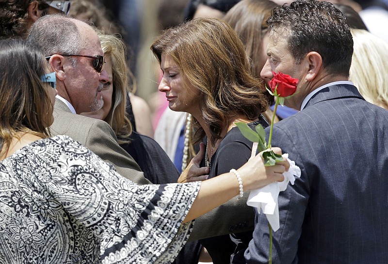 
              Dondie LeBlanc Breaux, mother of Mayci Breaux, center, and Kevin Breaux, right, father of Mayci, are comforted outside the Church of the Assumption, after her funeral in Franklin, La., Monday, July 27, 2015. She was one of two people killed in Thursday's movie theater shooting in Lafayette, La.  (AP Photo/Gerald Herbert)
            