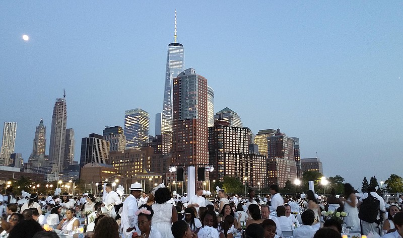 
              People dressed in white have dinner on Pier 26 along the Hudson River during the Diner en Blanc event, Tuesday, July 28, 2015, in New York. Thousands of people attended the world's largest popup picnic, at a location revealed at the last moment. (AP Photo/Verena Dobnik)
            