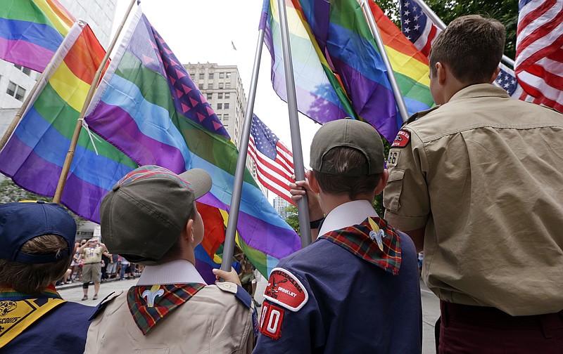 
              FILE - In this Sunday, June 28, 2015 file photo, Cub Scouts and Boy Scouts prepare to lead marchers while waving rainbow-colored flags at the 41st annual Pride Parade in Seattle, two days after the U.S. Supreme Court legalized gay marriage nationwide. On Monday, July 27, 2015, the Texas-based Boy Scouts of America ended its blanket ban on gay adult leaders but will allow church-sponsored Scout units to maintain the exclusion for religious reasons. (AP Photo/Elaine Thompson)
            