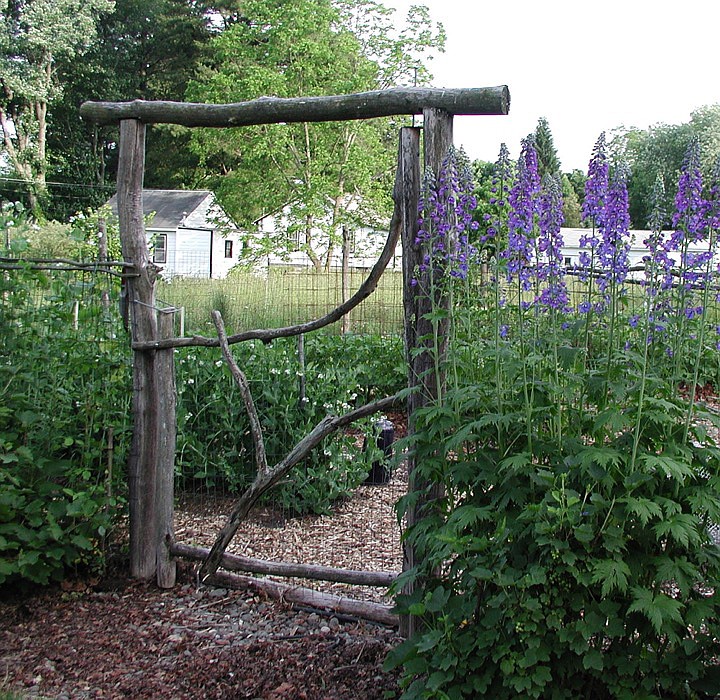 This rustic gate is made from locust wood, a rot-resistant wood that will protect and decorate this garden entrance for many years.