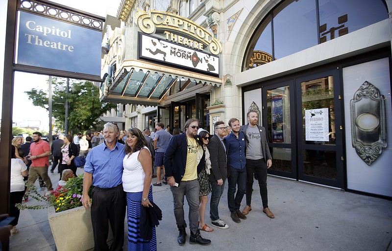 
              People pose for photographs before entering the Capitol Theatre to see "The Book of Mormon" musical Tuesday, July 28, 2015, in Salt Lake City. The biting satirical musical that mocks Mormons has finally come to the heart of Mormonlandia, starting a sold-out, two-week run Tuesday at the Salt Lake City theater two blocks from the church's flagship temple and headquarters. (AP Photo/Rick Bowmer)
            