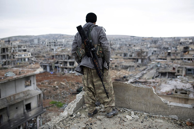 
              FILE - In this Jan. 30, 2015, file photo, a Syrian Kurdish sniper looks at the rubble in the Syrian city of Ain al-Arab, also known as Kobani. Turkey’s dramatic air campaign against the Islamic State and Kurdish forces has created a bit of a conundrum for President Barack Obama, who is leading the fight against one of Turkey’s targets while relying heavily on the other target.  (AP Photo, File)
            