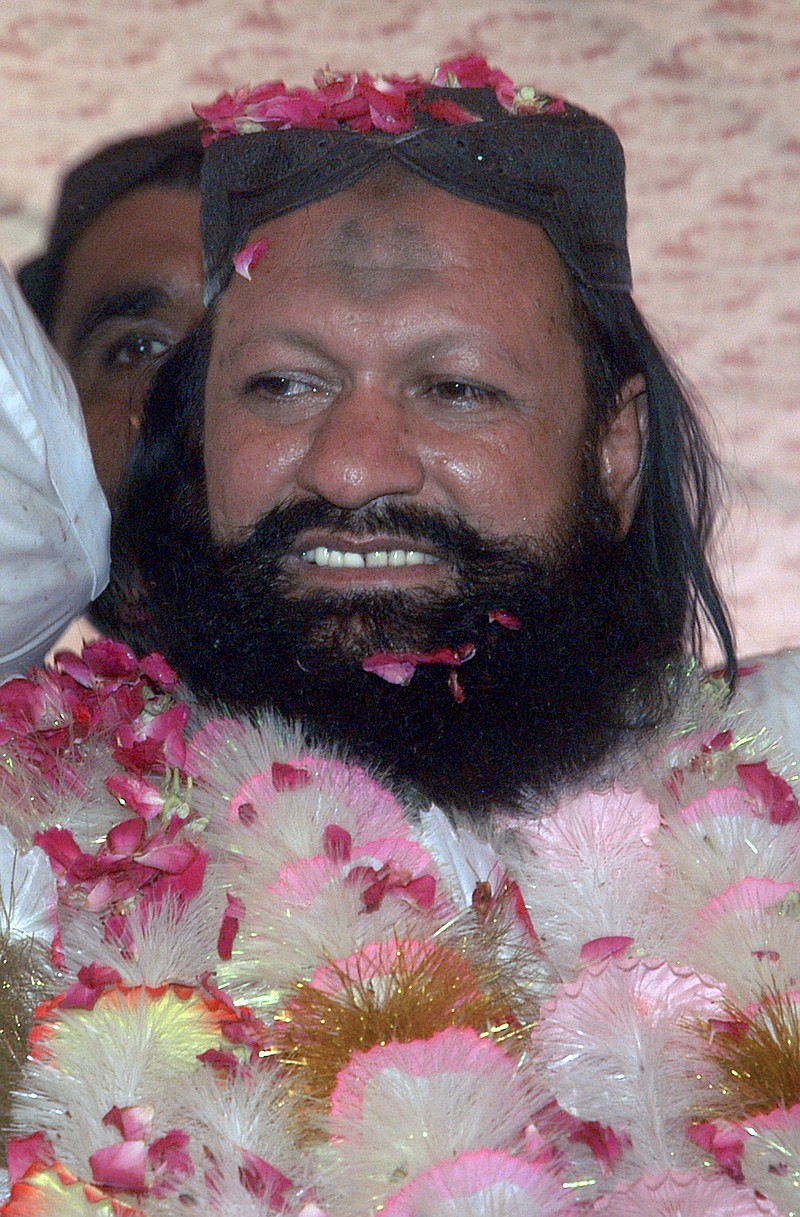 
              FILE - In this July 15, 2011, file photo, Malik Ishaq, a leader of the banned Sunni Muslim group Lashkar-e-Jhangvi, is greeted by supporters with rose-petals upon his arrival at his hometown in Rahim Yar Khan, Pakistan, after his release from jail. Pakistani police gunned down Ishaq, one of the country's most-feared Sunni militant leaders, and 13 followers in a mysterious pre-dawn shootout Wednesday, July 29, 2015, killing a man believed to behind the slaughter of hundreds of the nation's minority Shiites. (AP Photo/Khalid Tanveer, File)
            