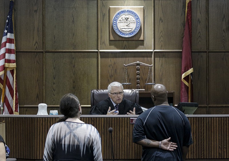 Judge Don Poole, left, speaks with Raymond Lounds at the bench during their check-in on the first official day of Hamilton County's new Mental Health Court.