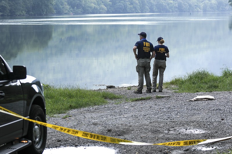 Investigators with the FBI Evidence Response Team search a pull-off along the Tennessee River from River Canyon Road on Thursday, July 30, 2015, in Chattanooga, Tenn. About 200 FBI investigators are still in Chattanooga to investigate the July, 16 shootings.