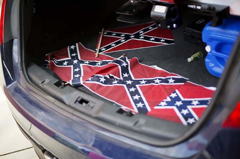 Confederate flags sit in the back of a police car outside Ebenezer Baptist Church Thursday, July 30, 2015, in Atlanta. U.S. authorities are investigating after several Confederate battle flags were discovered near the church and a civil rights center named after Martin Luther King, an iconic leader in the African-American Civil Rights Movement, Thursday morning. (AP Photo/David Goldman)